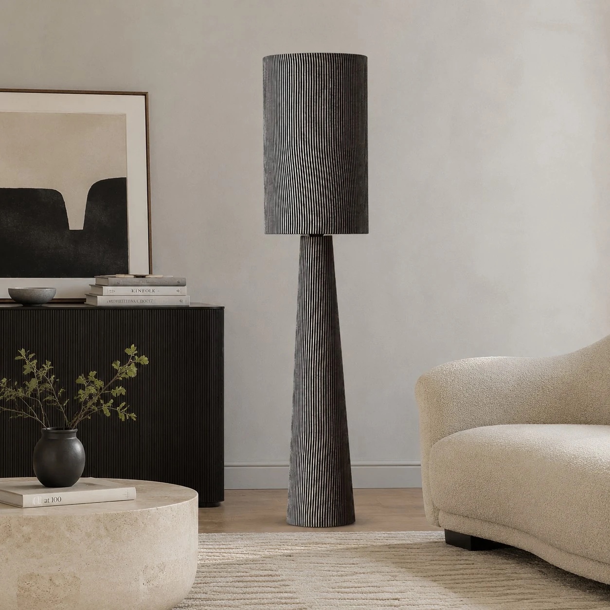 Gray striped floor lamp near a console and lounge chair