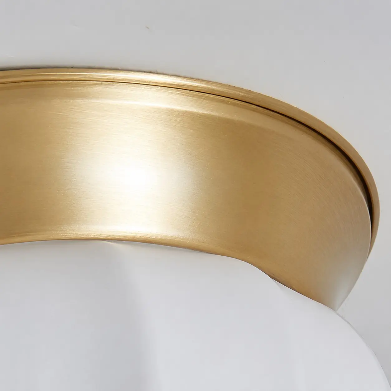 Close view of the brushed brass canopy and opal glass shade