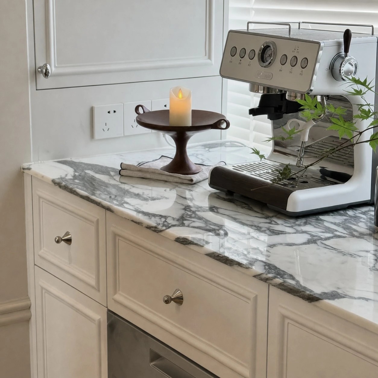 Polished silver-tone cabinet knobs installed on light kitchen cabinets