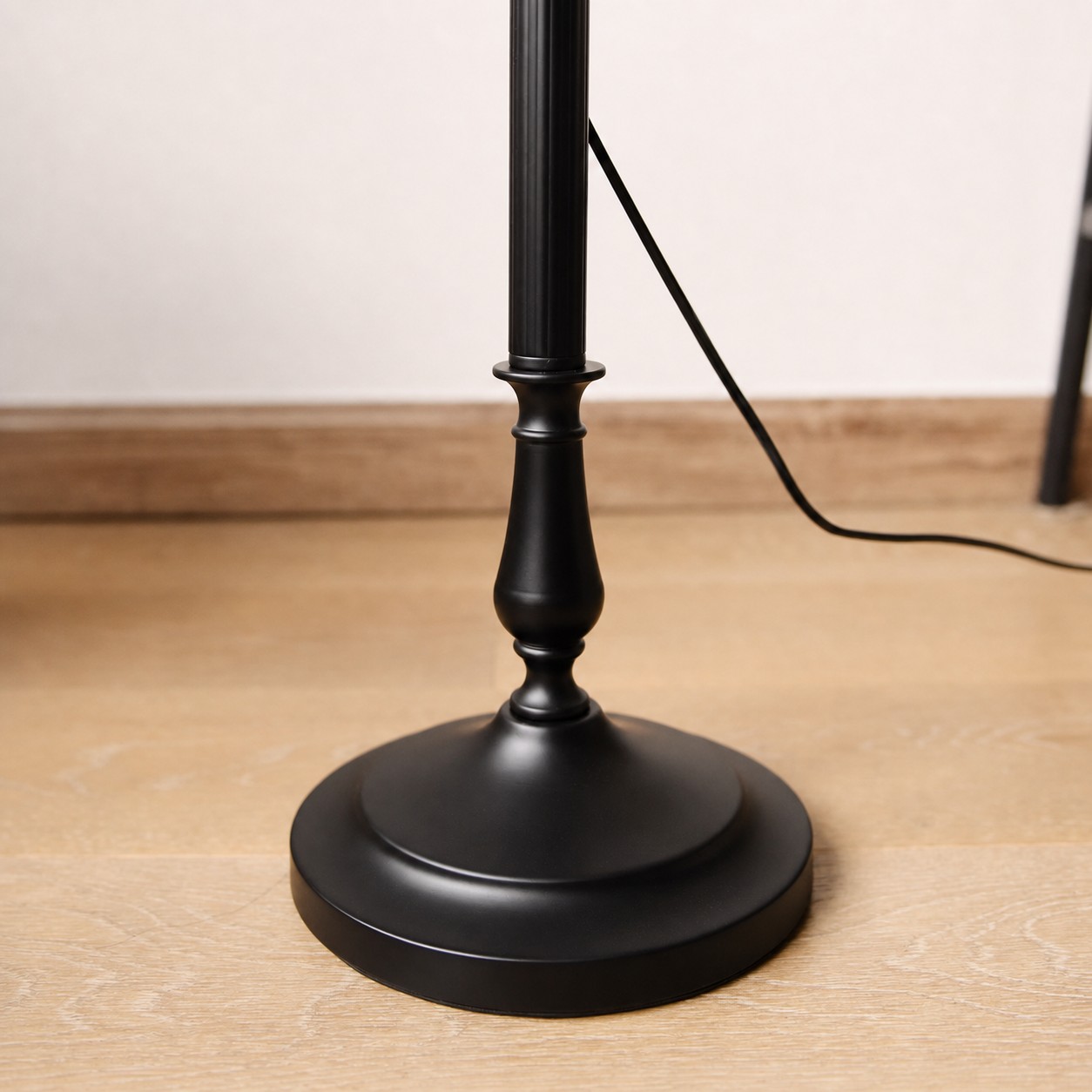 Black metal floor lamp base and foot switch cord detail