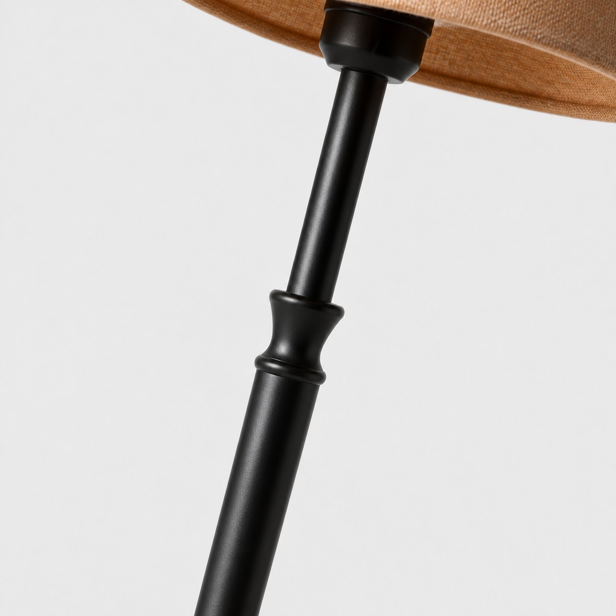 Close-up of black iron floor lamp stem and shade connection