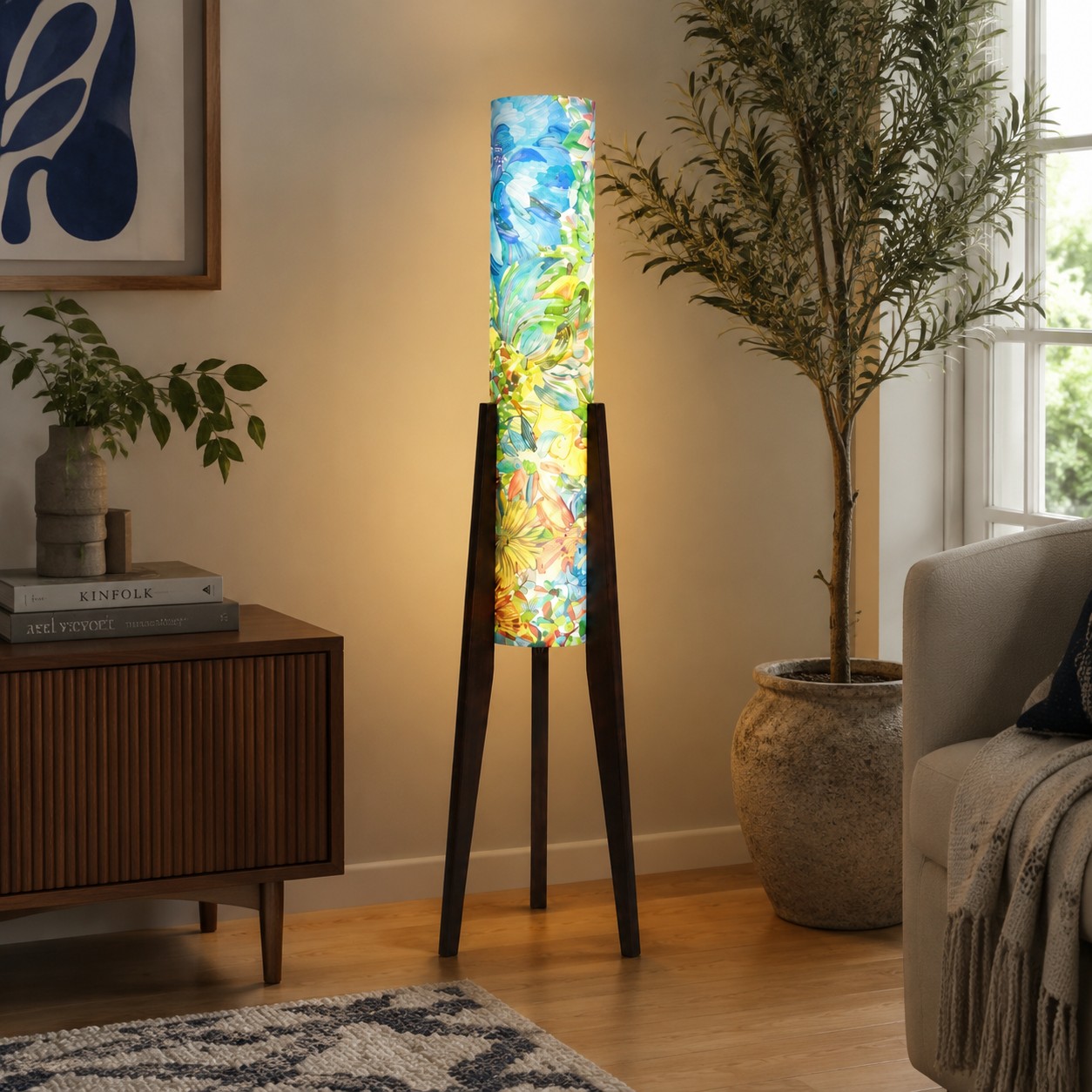 Blue botanical tripod floor lamp illuminating a quiet interior